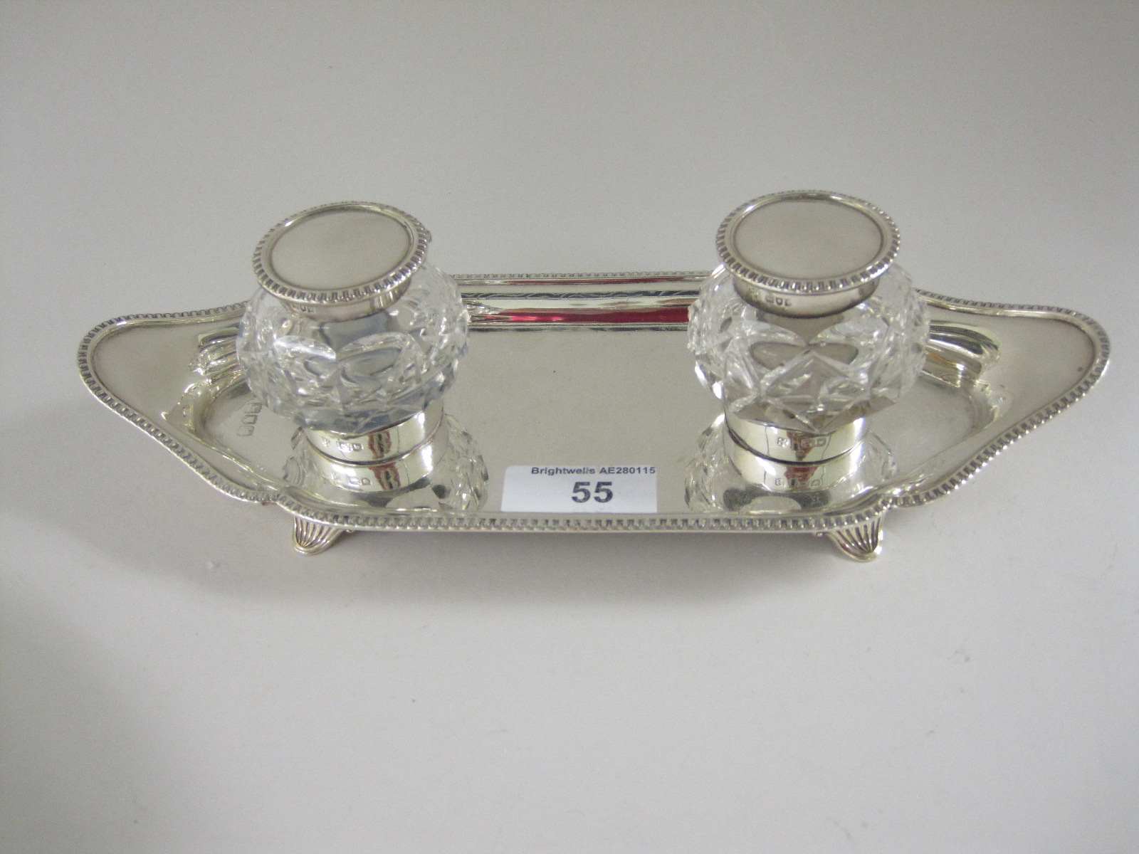 An Edward VII silver shaped oval Inkwell with egg and dart rim, fitted two lidded cut glass