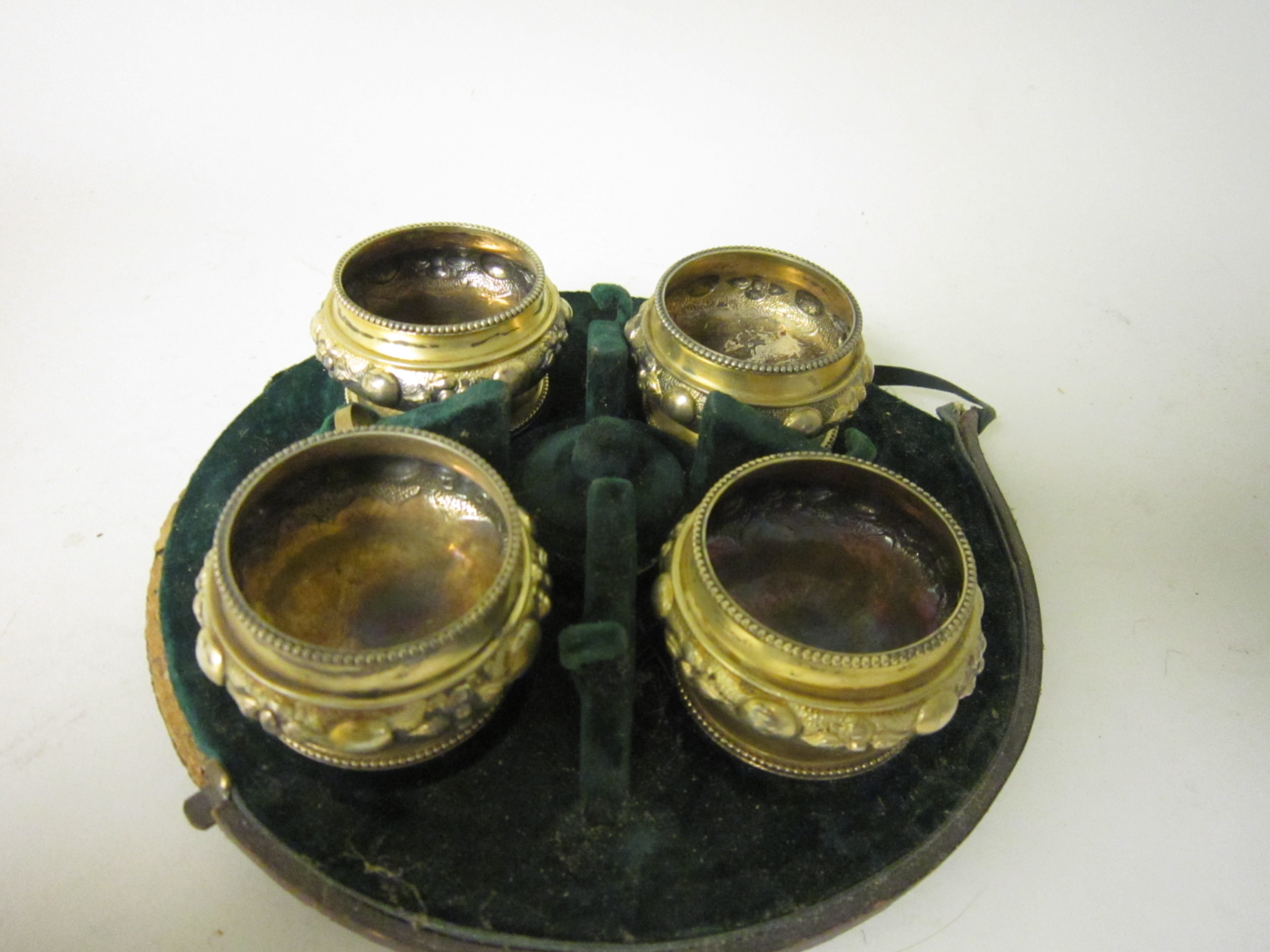 A set of four Victorian silver-gilt circular Salts with embossed friezes and beaded rims, London