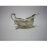 A modern heavy Irish silver Sauce Boat with floral and scroll embossing on mask supports and hoof