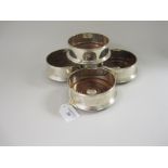 Four modern silver circular Coasters with turned wooden bases and central discs engraved initials,