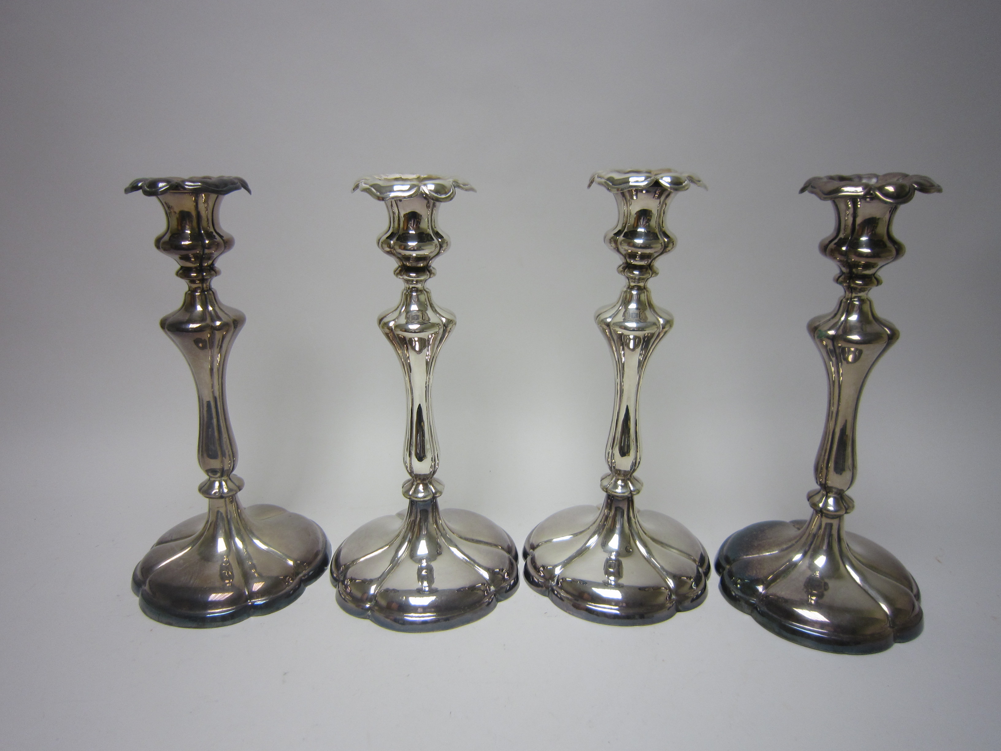 A set of four plated Pillar Candlesticks on lobed circular bases