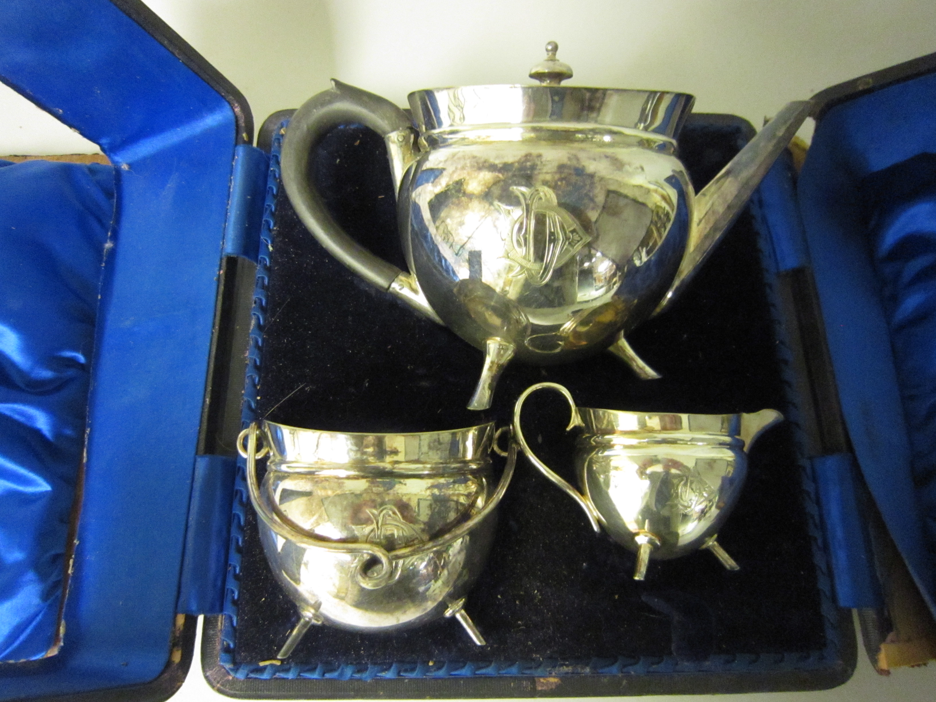 An Aesthetic Movement plated three piece Tea Service, engraved initials on peg feet, in case