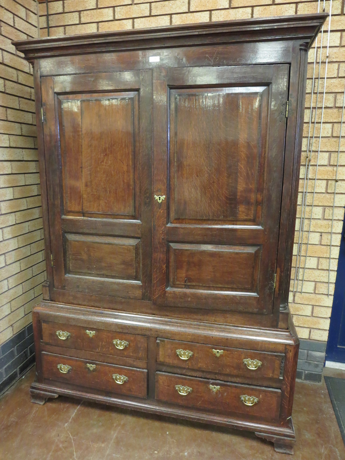 An 18th Century oak Hall Cupboard with pair of cross-banded and fielded panelled doors enclosing