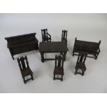 A suite of ‘dark oak’ Elgin Dolls House Furniture comprising a settle, armchair, four dining chairs,