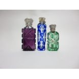 Three overlaid glass Scent Bottles in blue, green and amethyst with white metal lids and stoppers