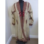 A fine antique Indian Maharaja’s cream day Coat with bands of  paisley like polychrome embroidery.