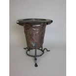 An Art Nouveau hammered copper flare rimmed Jardiniere on tripod base with embossed thistle