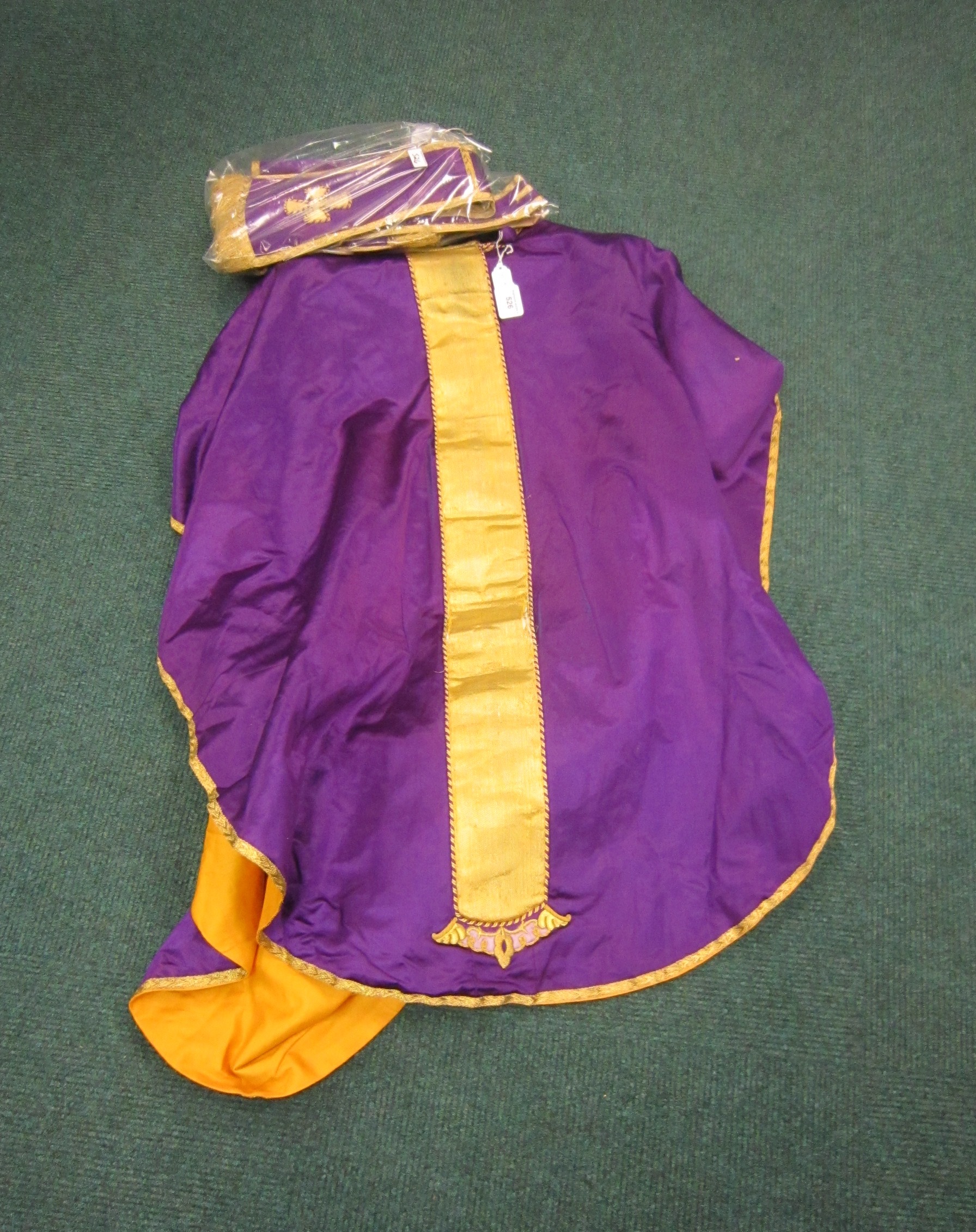 A purple satin and metallic gold Chasuble with raised IHS Christogram, lined in orange, with