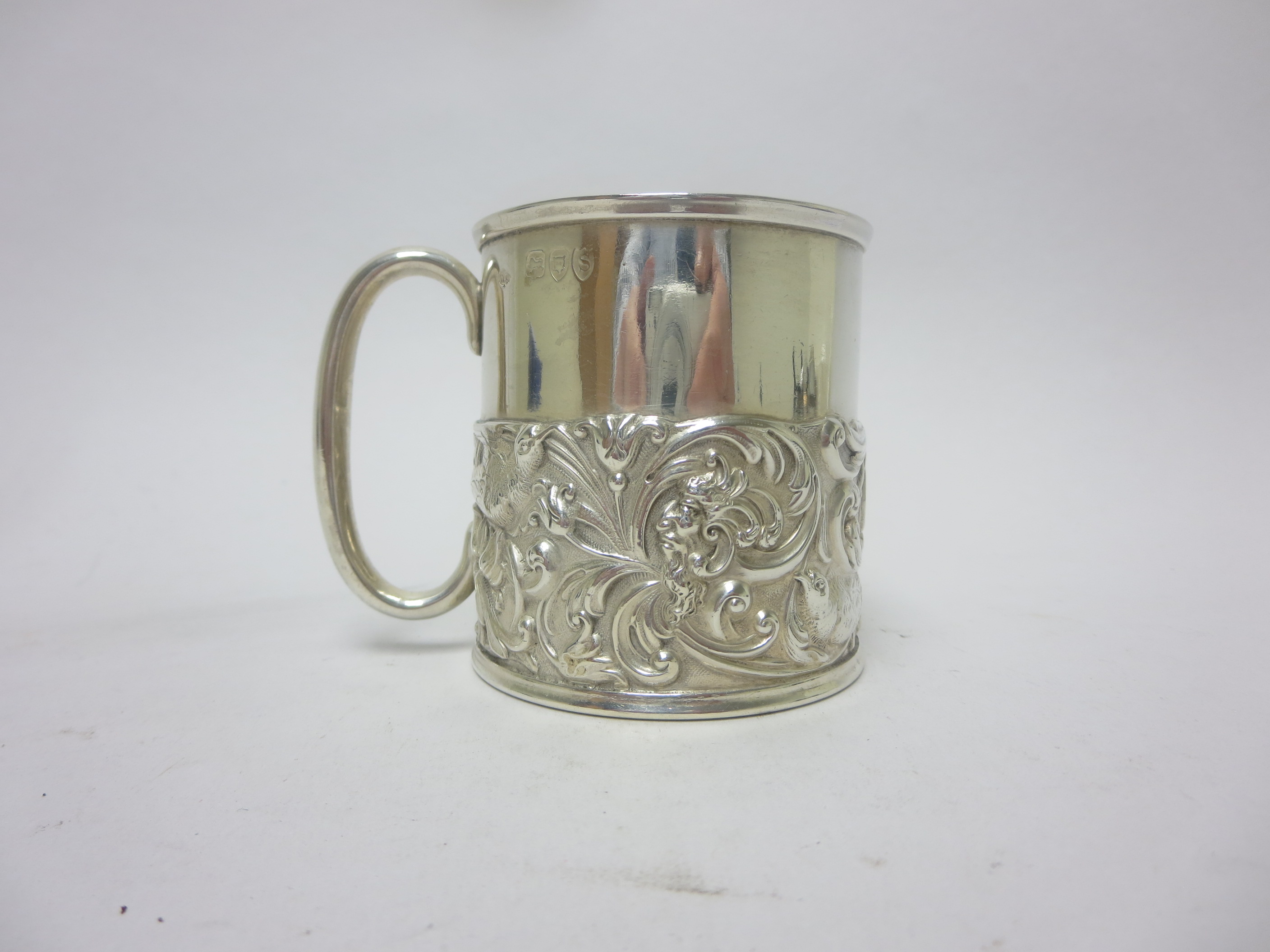 A Victorian silver Christening Mug embossed birds and scrolls, London 1893, maker: Wm Comyns