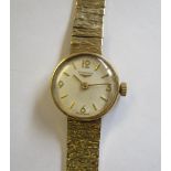 A Lady’s Longines Wristwatch the champagne dial with arabic numerals and baton markers on textured