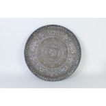 A large Islamic Tray inlaid with silver script and copper decoration, 19in diam