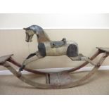 An English carved wooden Rocking Horse, the bow rockers with facing seats for two children, glass