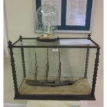 A wooden model of a three masted Tall Ship, ‘Swift’, in a glazed case and a glass model of a ship