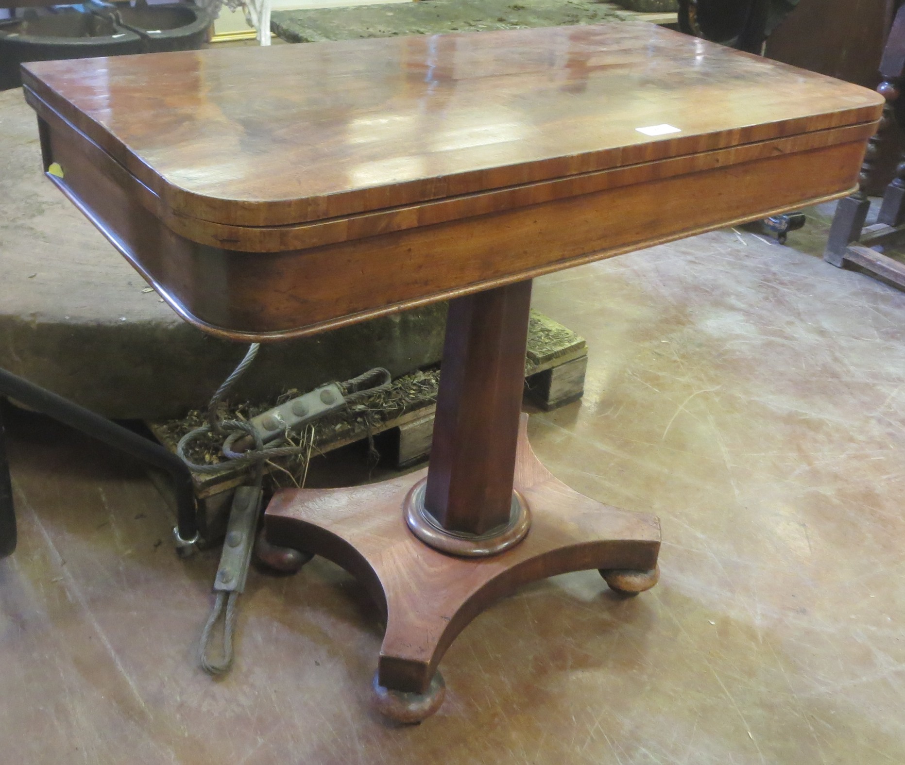 A 19th Century mahogany Card Table with fold-over top on tapering octagonal column and platform