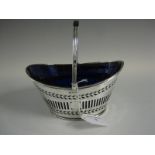 An Edward VII oval silver Basket with pierced and engraved decoration, swing handle, blue glass