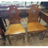 A matched pair of mahogany Victorian Hall Chairs with carved shaped backs, one on octagonal shaped