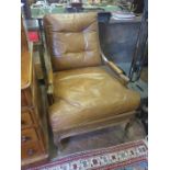A tan leather covered 19th Century walnut open Armchair, the square back and downswept arms above