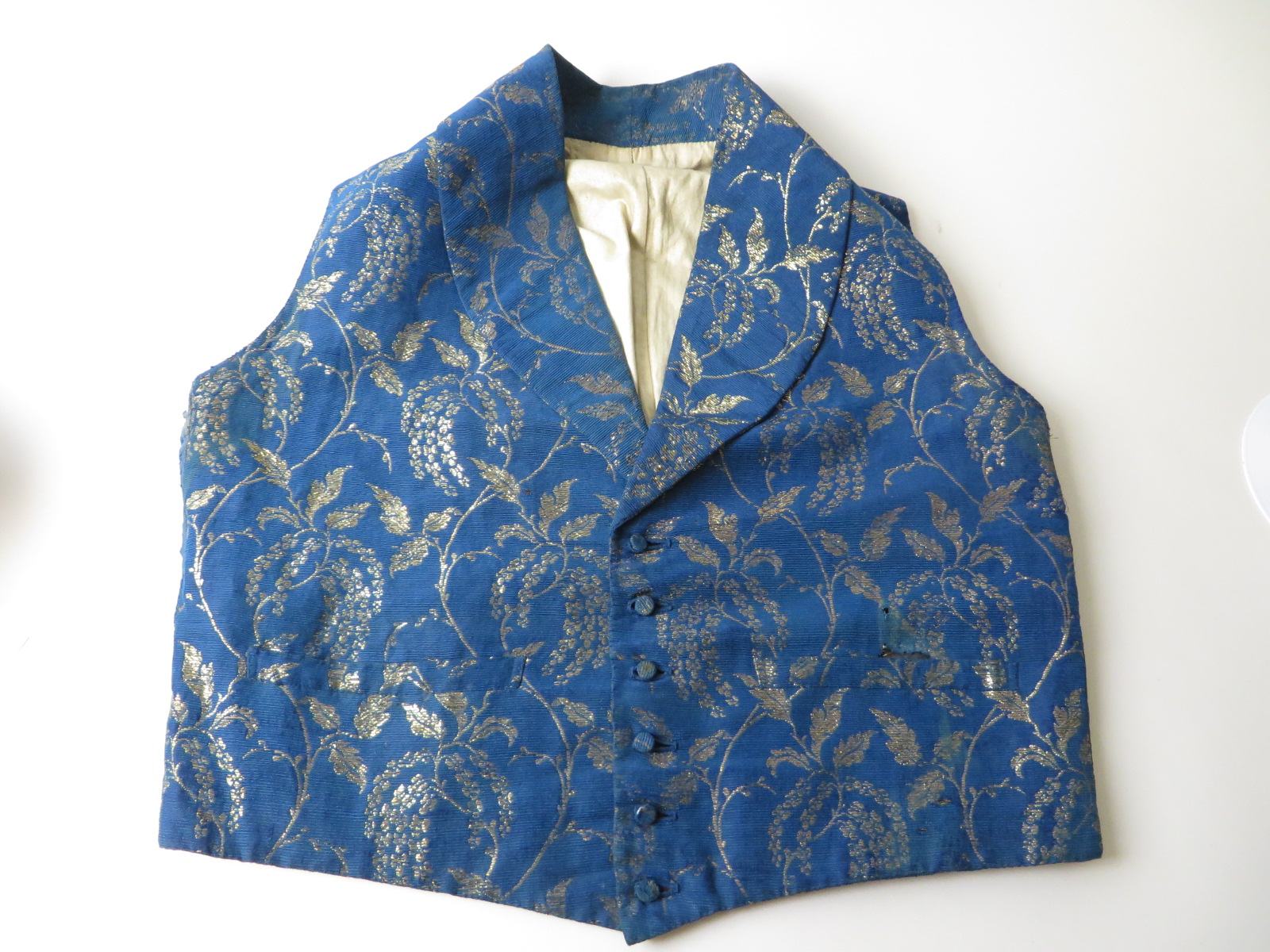 A man’s blue ribbed silk Waistcoat made from fabric used for Queen Victoria’s train. In 1900