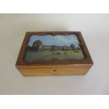 An oak Box, the hinged lid with inset painted panel of Paris Exhibition within shaped frame, 9 1/2in