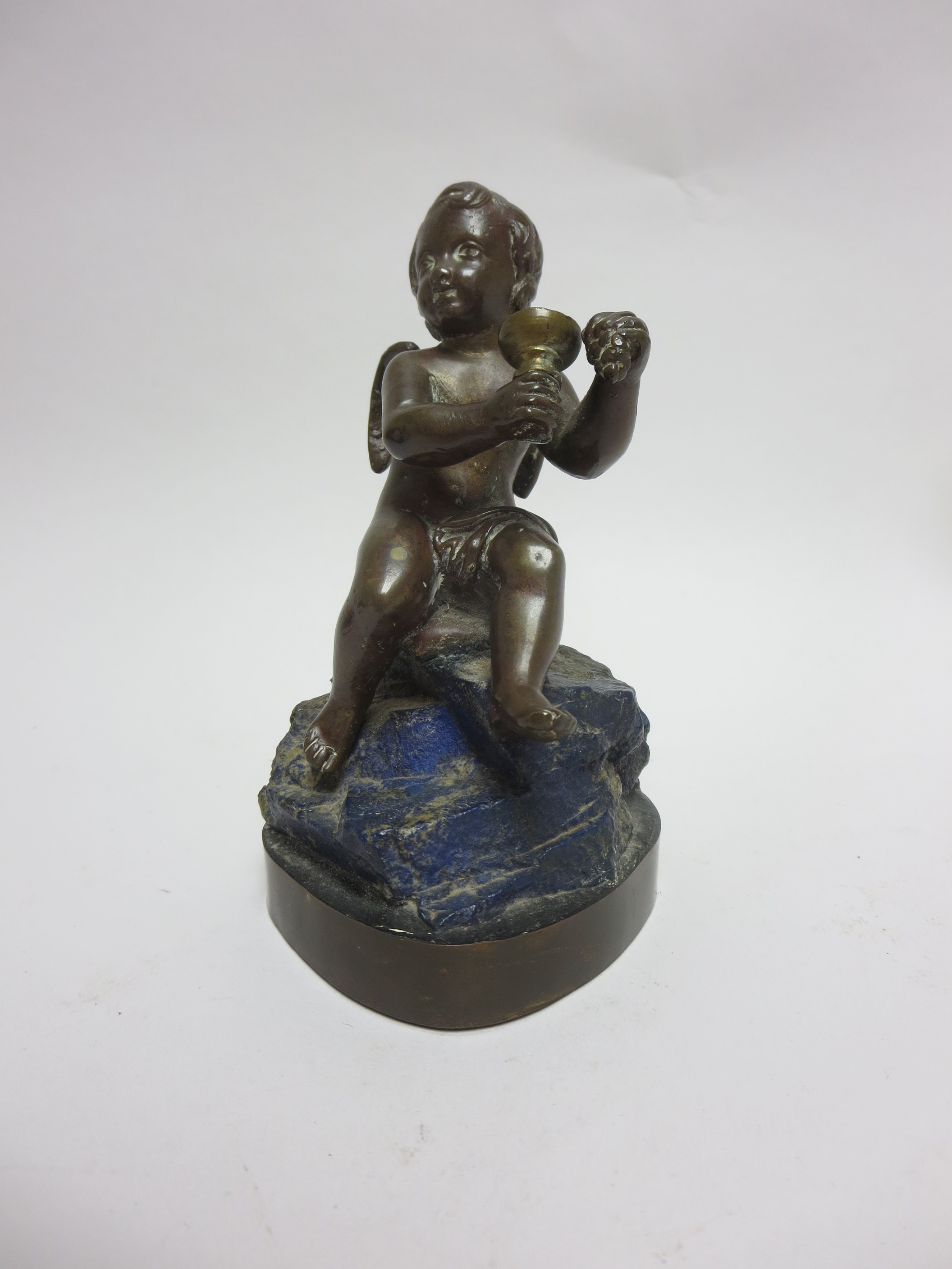 A bronze Figure of Bacchus seated on a lapis rock and shaped square base, 6in
