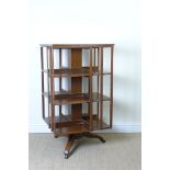 An Edwardian walnut revolving Bookcase on tripod base and casters, 3ft 7in H