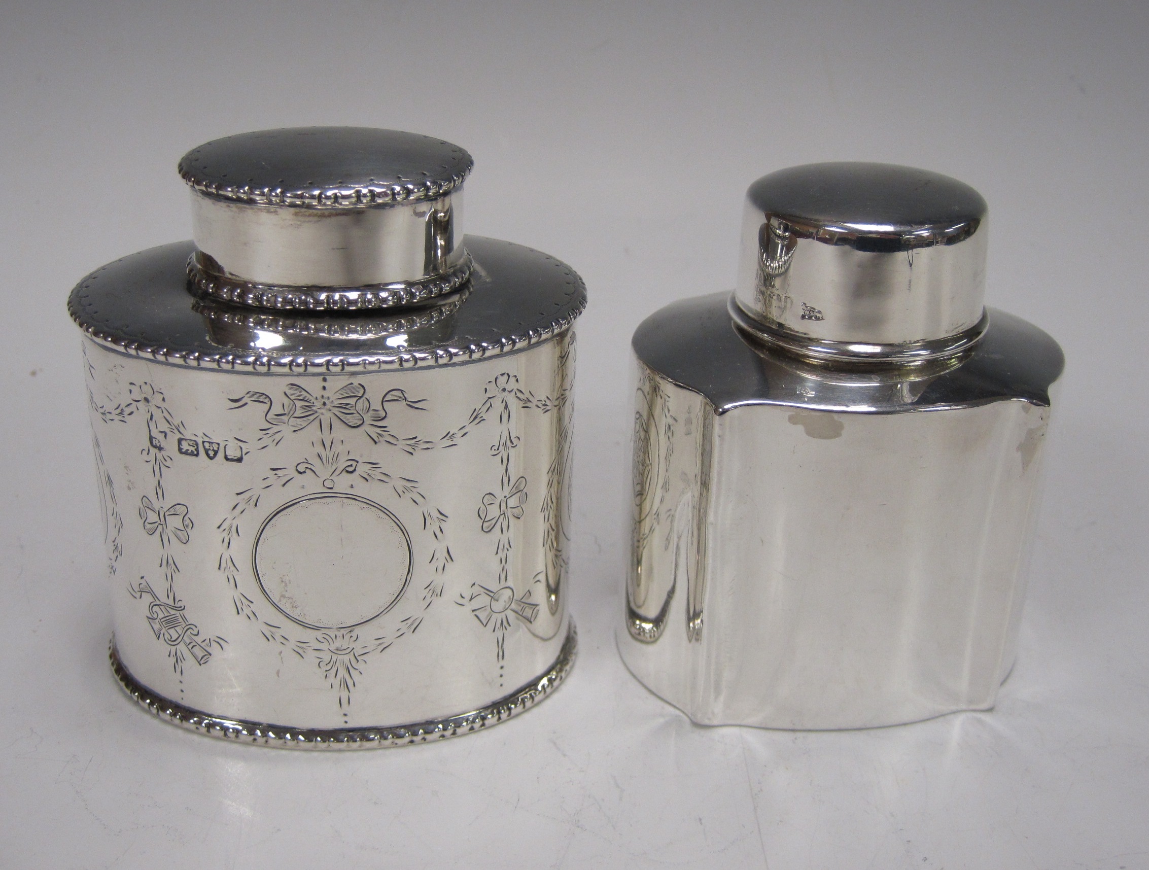 An oval silver Tea Caddy with swagged decoration, Chester 1911, and an Edward VII silver shaped