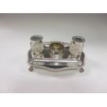 An Edward VII silver Inkstand fitted two cut glass ink pots, gadroon rim on paw feet, London 1908