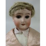 A Schoenau & Hofmeister bisque headed Doll with heavy brows and brown eyes. Fully jointed body.