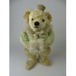 A fine and rare green and gold mohair and silk plush Chiltern Skating Bear with muff. Painted back