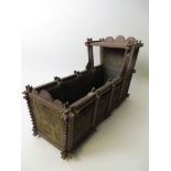 An ornate Doll’s Cradle with inset velvet panels and glazed sides to canopy. Probably Russian.