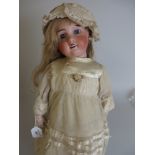 A Limoges bisque headed Bébé Doll with fixed blue eyes, pierced ears and moulded teeth, fully
