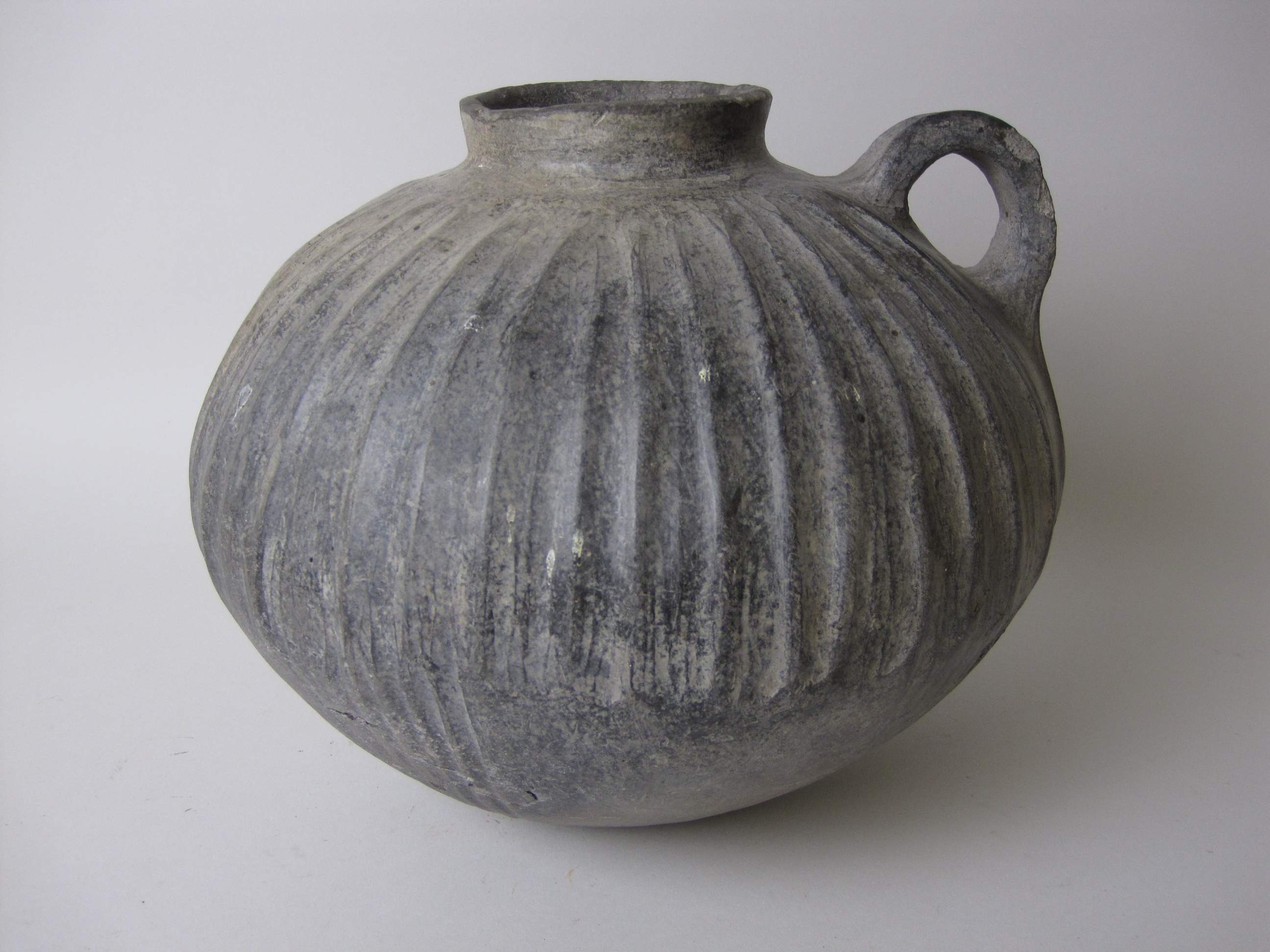 An ancient near Eastern black burnished ware Vessel, spherical body with vertical ribbing, raised