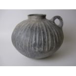 An ancient near Eastern black burnished ware Vessel, spherical body with vertical ribbing, raised