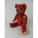 A bright red fully jointed Teddy Bear with painted back eyes and slightly up-turned nose. One pad
