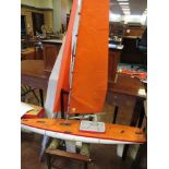 A radio controlled wooden single masted Racing Yacht with white painted hull and weighted keel, no