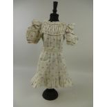 An original flower sprigged Jumeau Dress circa 1890, 17in L and a pair of Jumeau shoes with