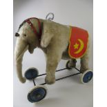 A Steiff Elephant on wheels with original blanket and trappings. Button in ear and yellow label also