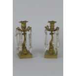 A pair of Regency gilt brass lustre Candlesticks modelled as sea monsters on rectangular bases, 9