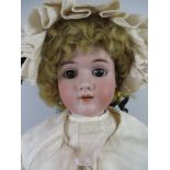 A large bisque headed Handwerk Doll with large brown eyes and pierced ears. Fully jointed body.