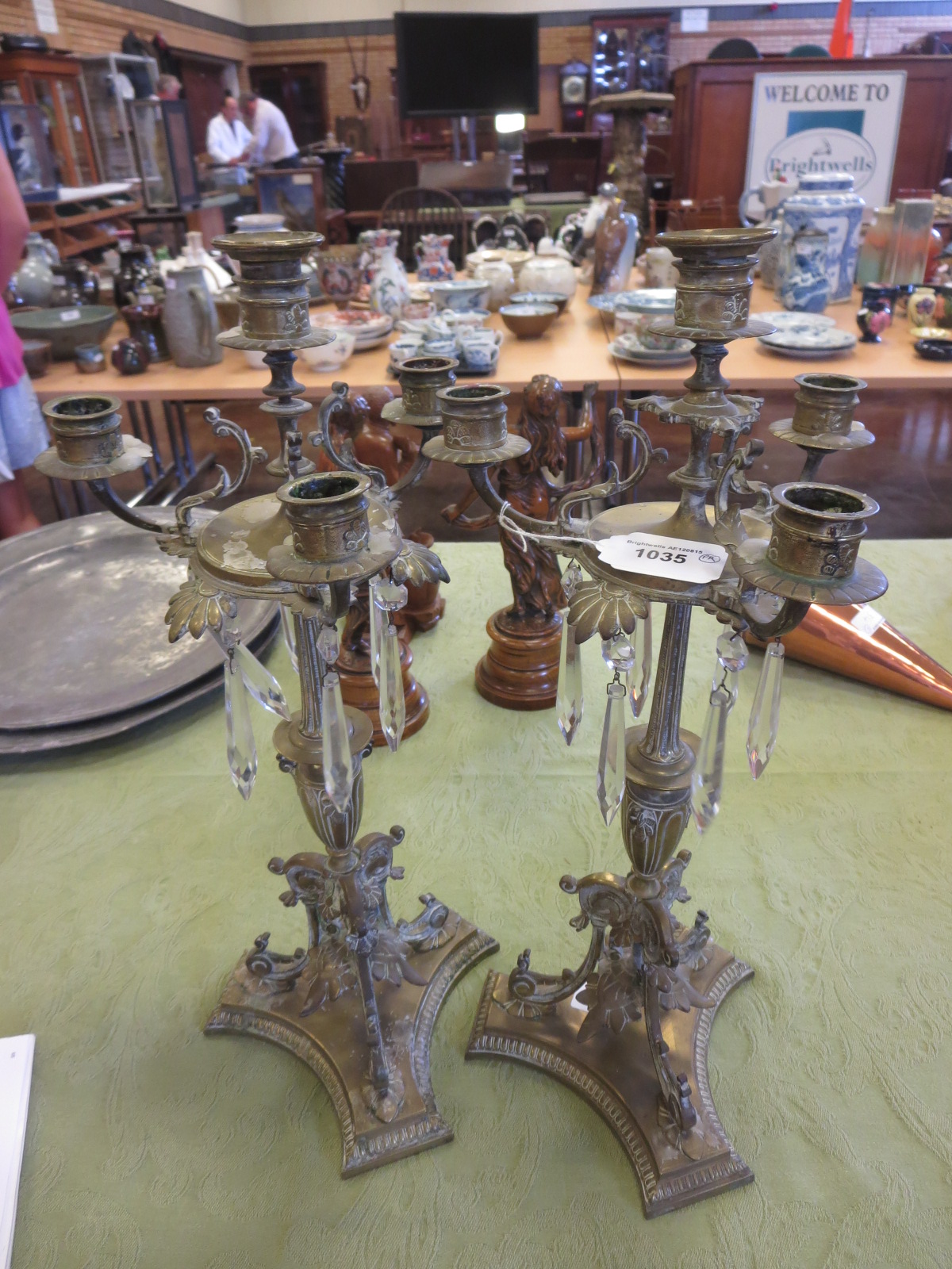 A pair of brass Candelabra with four sconces above glass droppers and vase shaped columns. 17 1/