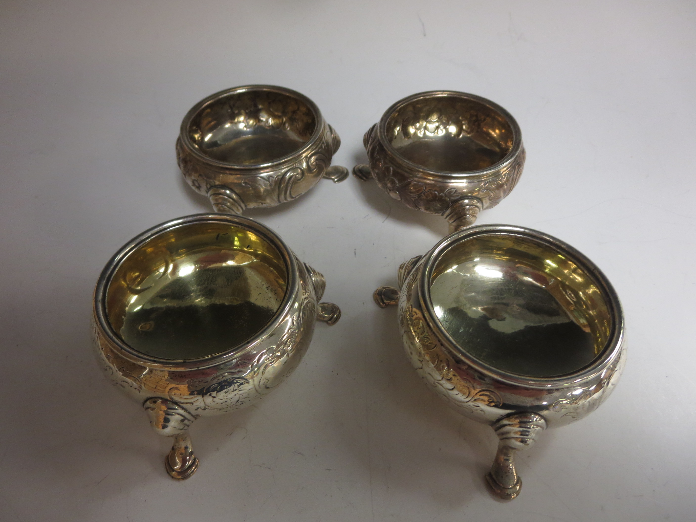 A pair of Victorian silver Cauldron Salts, floral engraved on hoof feet, London 1848 and another