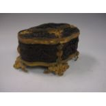 A Continental shaped oval Trinket Box with moulded brass mounts and four scroll feet, decorated with