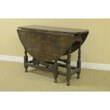 An antique oak Gateleg Table fitted frieze drawer on baluster turned supports and squared