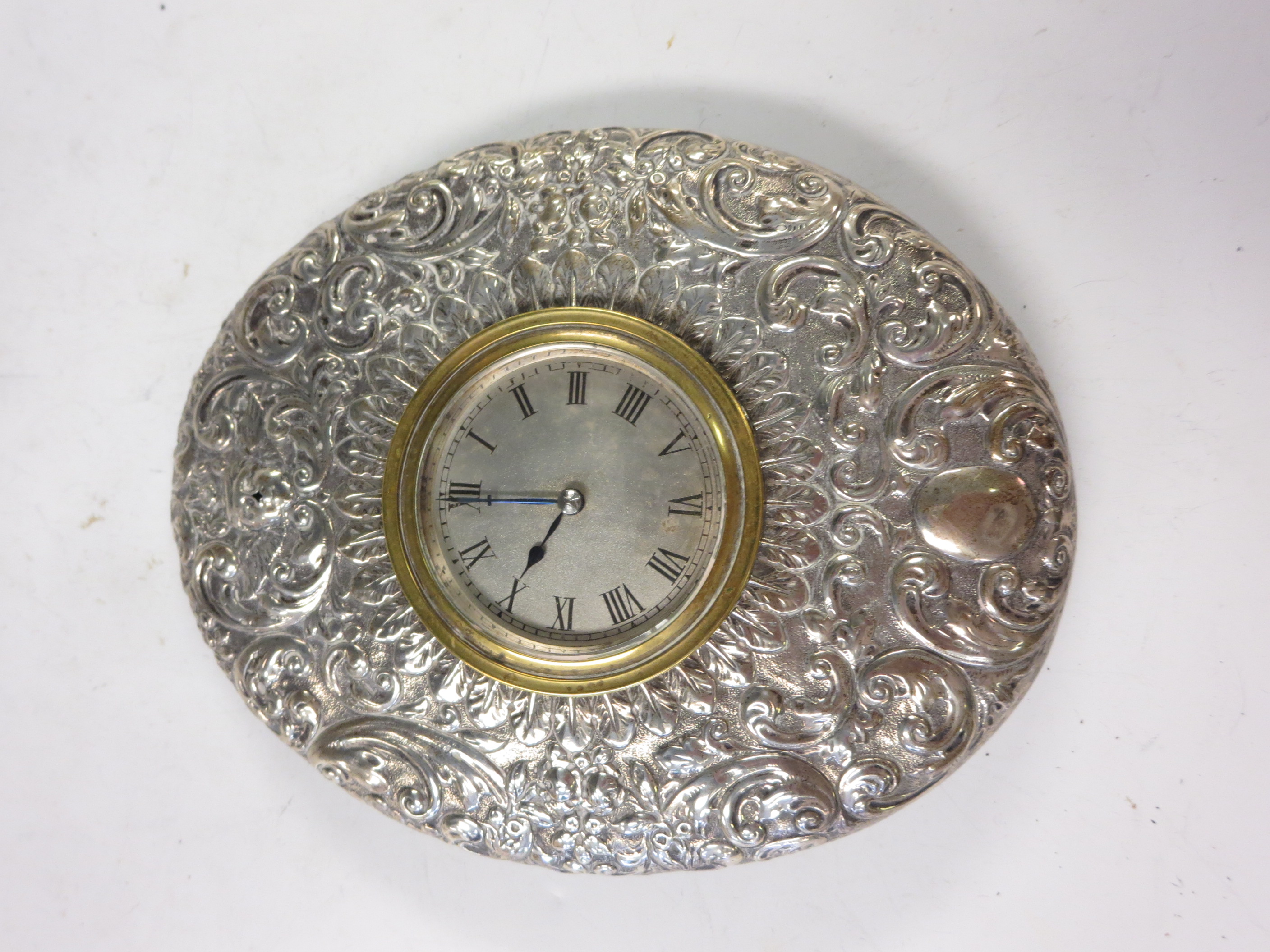 A Victorian silver oval cased Easel Clock with mask, leafage and scroll embossing, London circa