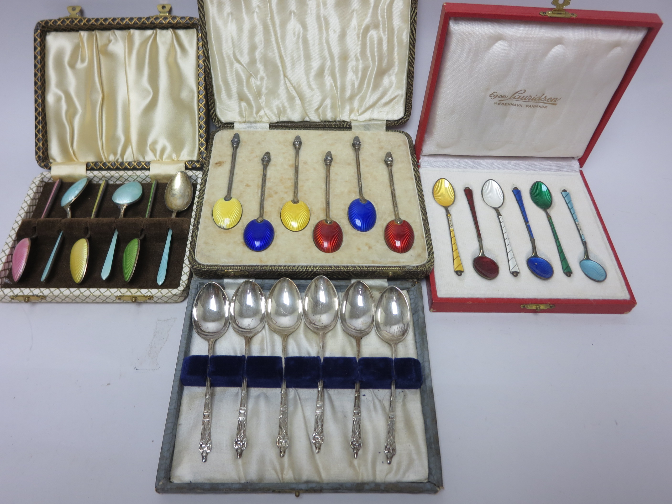 Three sets of silver and enamel Coffee Spoons and six plated apostle handled Coffee Spoons, all