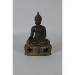 A Burmese bronze seated Budha with folded legs on raised base with elephant mask decoration, 9in H