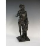 A bronze standing figure of Bacchus with fruiting vine and leaf decoration on square plinth base,