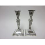 A pair of Victorian silver Candlesticks with ribbon and swag design, tapering columns on beaded