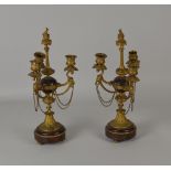 A pair of three branch ormolu and rouge marble Candlesticks with goat mask decoration, chains and