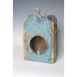 A 19th Century primitive blue painted pine Candle Case with shaped top above circular glazed